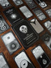 The Eigengrau Oracle Deck Limited Drop by Rage Create features dual-sided oracle cards with surreal black and white art—eyes, skulls, geometric motifs—spread on wood. The central card displays the deck’s title.
