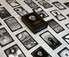 A black-and-white box labeled "The Eigengrau Oracle Deck Limited Drop" by Rage Create rests on a cloth, surrounded by hand-drawn oracle cards with abstract and surreal designs.