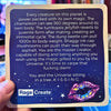 Card with text and a colorful lip graphic, held by a hand.