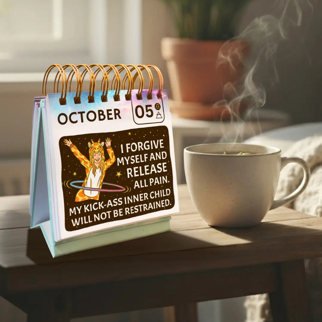 Calendar on a table with a mug of tea and a plant in the background