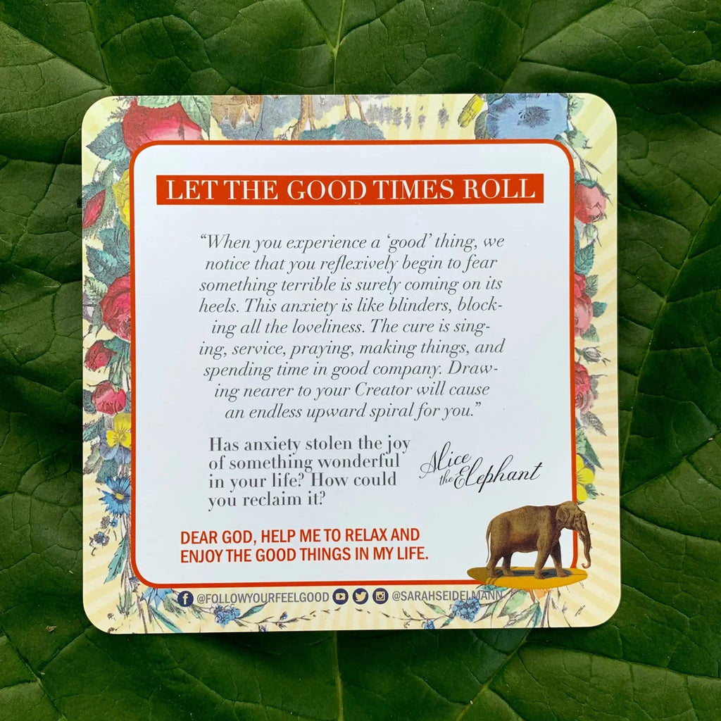 A motivational card from the deck featuring floral borders and an elephant illustration, with an inspirational quote about anxiety and joy, displayed on lush green leaves.
