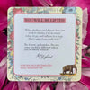Inspirational card with 'You Will Be Lifted' header, featuring Alice the Elephant affirmation text on cream background with vintage floral border, displayed against bright magenta tulle fabric.