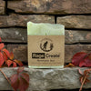 Pale green Rage Create Mountain Air soap bar with kraft paper label featuring Cullowhegh Farms branding, displayed on rustic stone brick wall surrounded by burgundy and orange autumn leaves.