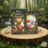 Oracle of the Magical Fairy Forest box and The Portal card displayed on a wooden slice with clear quartz crystals, a red mushroom, and moss in a lush green forest setting beside a flowing stream.