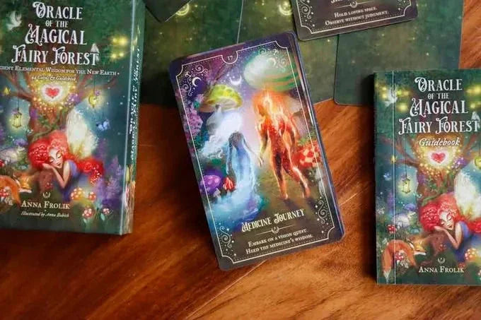 Oracle of the Magical Fairy Forest deck displayed on warm wood with guidebook and colorful tarot cards featuring ethereal fairies and magical creatures in purple and gold tones.