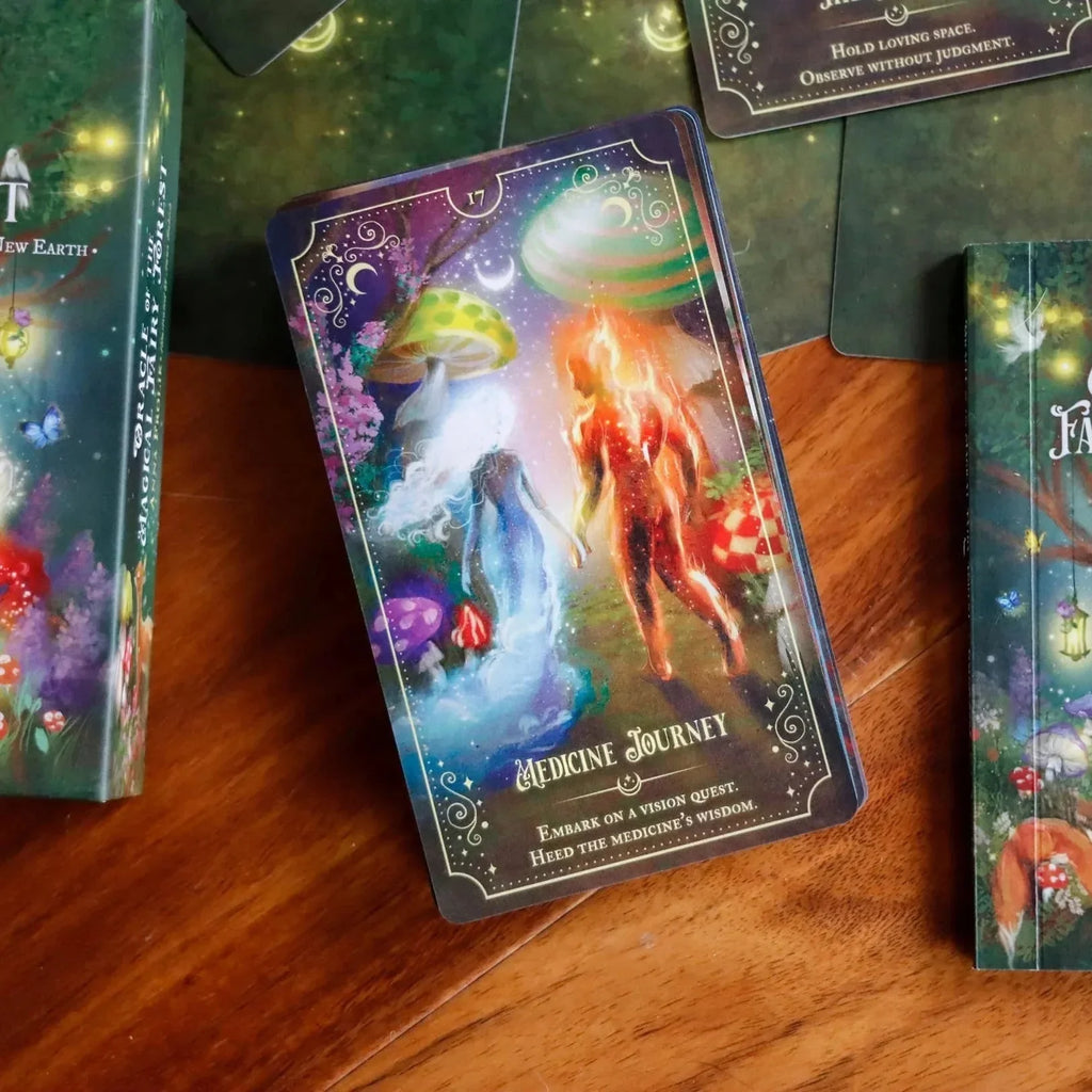 Card 17 from the Oracle of the Magical Fairy Forest deck displayed on warm wood, featuring an ethereal figure surrounded by glowing orange flames and mystical celestial imagery with purple and gold ac