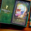 Open oracle deck box displaying 'The Portal' card with an illustration of a fairy in a pink dress stepping through a glowing celestial gateway surrounded by colorful flowers, with an emerald-green ins