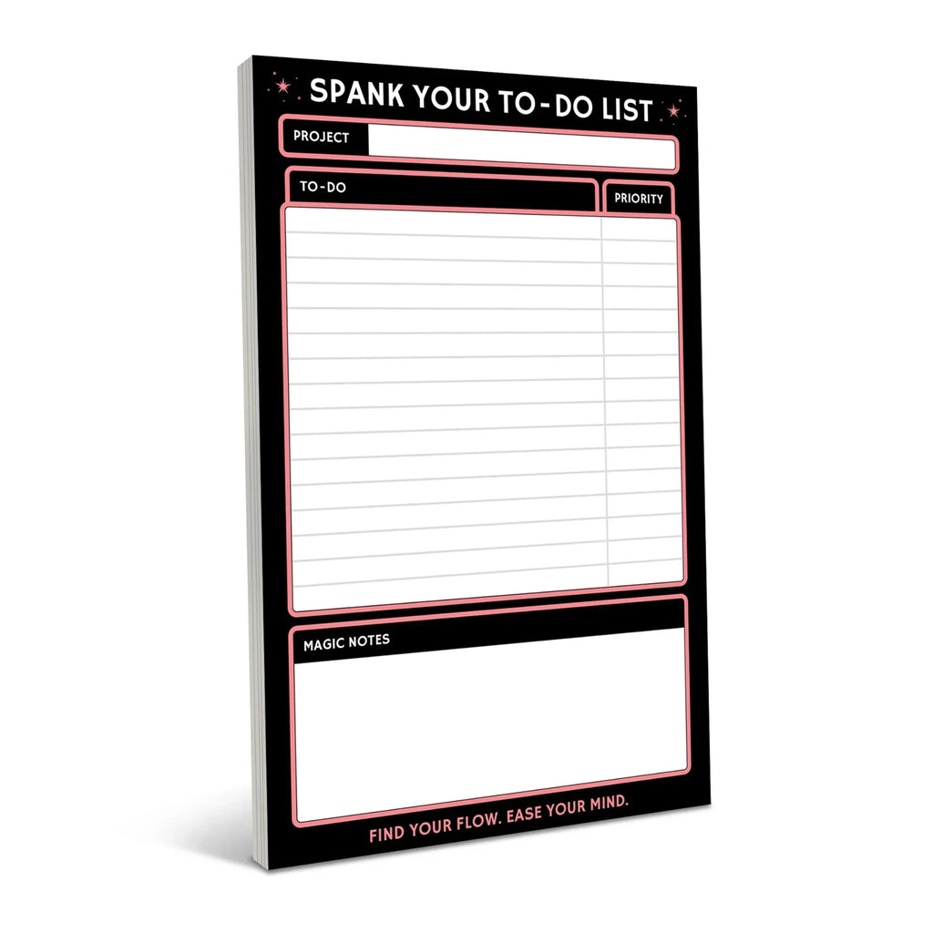 Black notepad with neon pink border featuring "Spank Your To-Do List" header, project field, to-do checklist area, priority box, and magic notes section with motivational tagline at bottom.