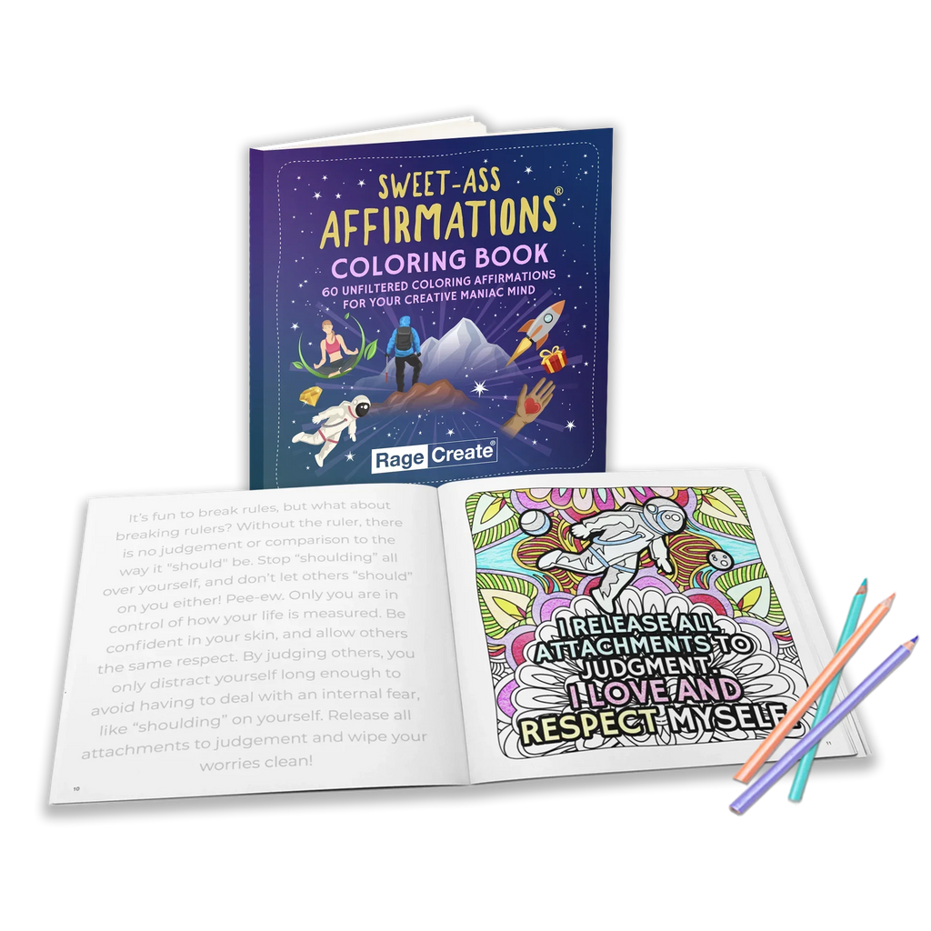Open Sweet-Ass Affirmations coloring book displaying an intricate mandala-style affirmation page with colorful markers and pencils alongside the purple-covered book featuring illustrated astronauts an