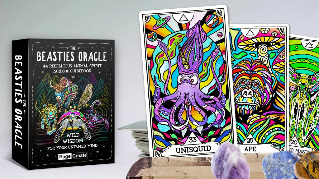 The Beasties Oracle tarot box with colorful animal spirit cards fanned out, featuring a vibrant purple squid and patterned ape card, alongside polished crystals on a natural wood surface.
