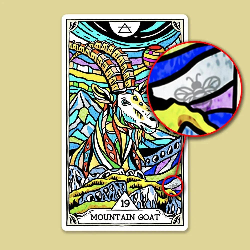 Colorful tarot card featuring a vibrant mountain goat with ornate patterned horns against a turquoise and multi-hued background, with detail circles highlighting the card's intricate stained-glass art